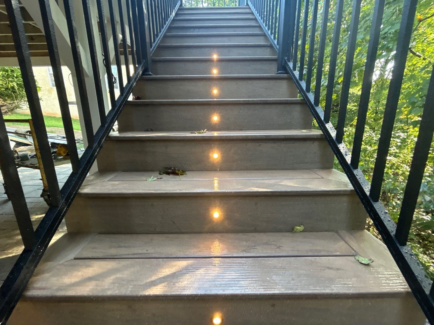 Composite deck staircase with glowing LED step lights and black railing at a home on the Main Line, PA